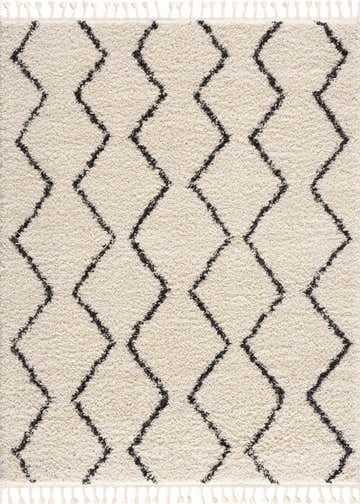 Close-up of the West End Plush Area Rug. Light beige shag rug with a charcoal geometric diamond pattern and fringe. Design-Rectangle