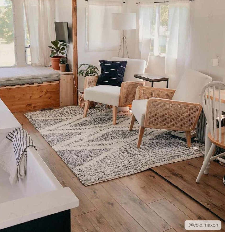 Living room scene with a charcoal and cream Trunding Plush Area Rug, rattan chairs, and wood accents. Roomscene-Rectangle