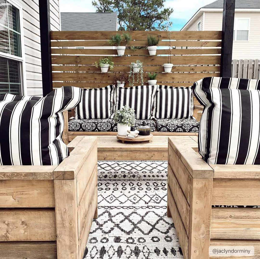 Outdoor patio with wood furniture and black and white Westside Outdoor Area Rug. Roomscene-Rectangle