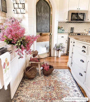 Farmhouse kitchen scene with Bodrum area rug, white cabinets, wood floors, and pink flowers. Roomscene-Rectangle