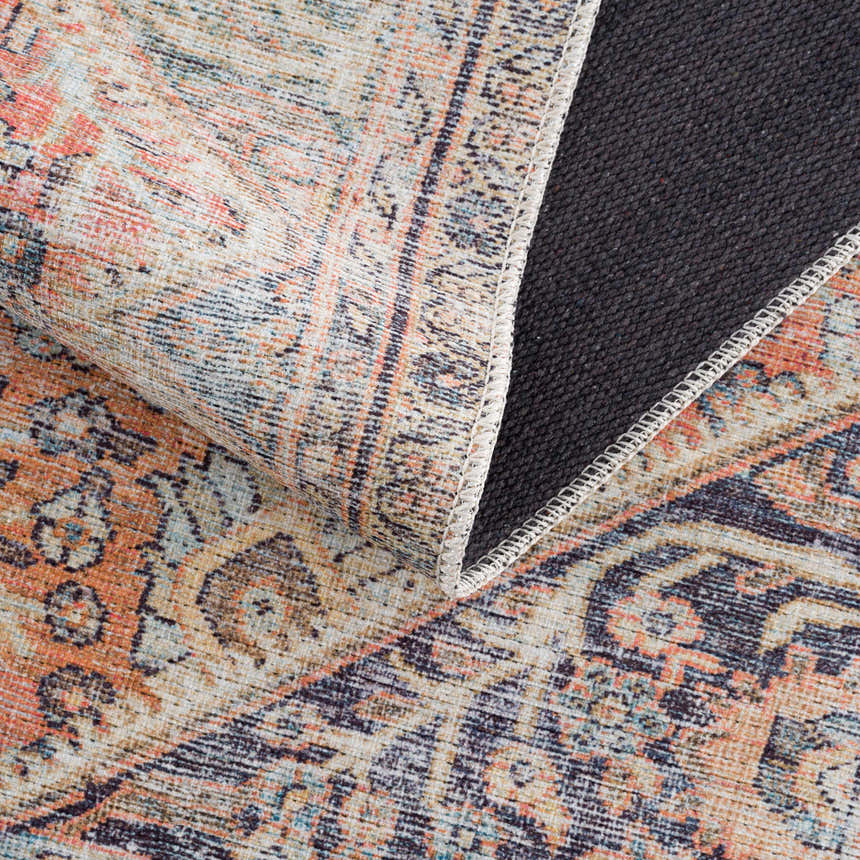 Close-up of Konstantina Washable Area Rug showing beige, aqua, and peach vintage Persian-style pattern and non-slip backing. Fold