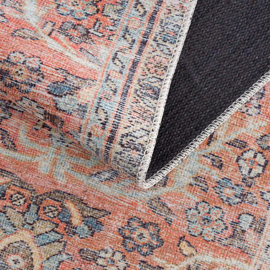 Close-up of the Urpi Rose & Blue Washable Area Rug showing its traditional Persian pattern, rose, blue, and beige colors. Fold