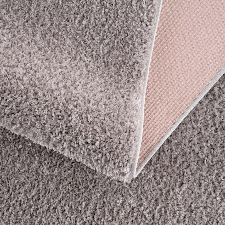 Close-up of the plush texture and backing of the Judy Solid Gray Washable Shag Rug. Fold