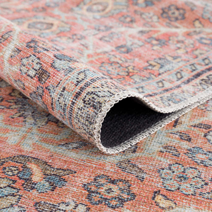 Close-up of the Urpi Rose & Blue Washable Area Rug showing its traditional Persian design, rose, blue, and beige colors. Fold