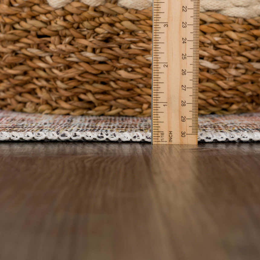 Close-up of Flat Pile Urpi Red Washable Rug showing its flat construction, edge binding, and multi-color vintage pattern. Pile