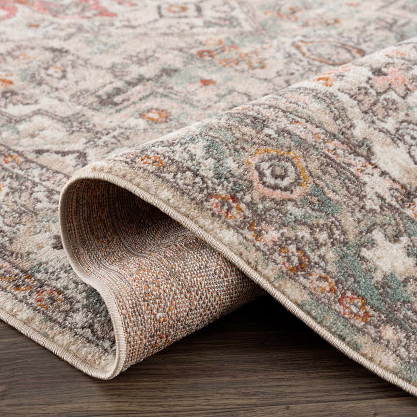Close-up of the Bolinas Area Rug showing its brick red, camel, and light gray traditional pattern and machine-woven texture. Fold