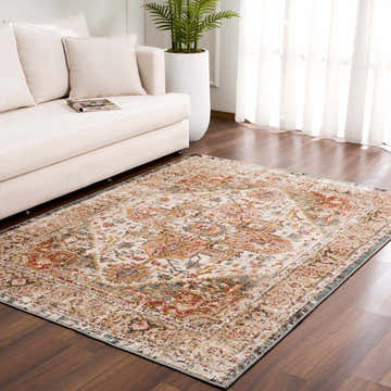 Living room scene with a cream sofa and the Hauteloom Peeta Rug in brown, cream, pink, and red on a dark wood floor. Roomscene-Rectangle