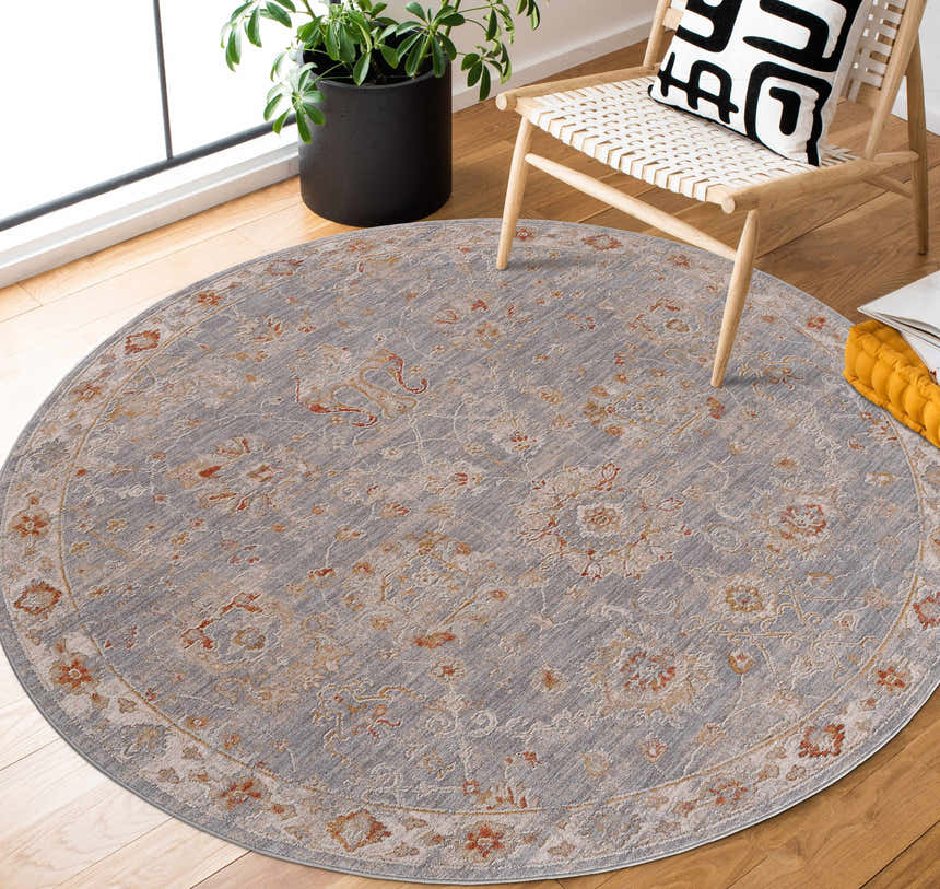Light-filled room with round Mangham Thick Luxe Area Rug in blue, brick red, and beige under a modern chair. Roomscene-Round