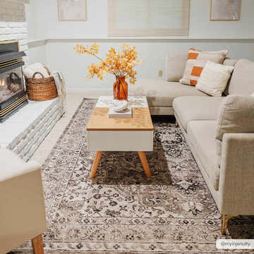 Living room scene with beige Albie Area Rug, sectional sofa, and modern coffee table. Neutral tones create a cozy, inviting space. Roomscene-Rectangle