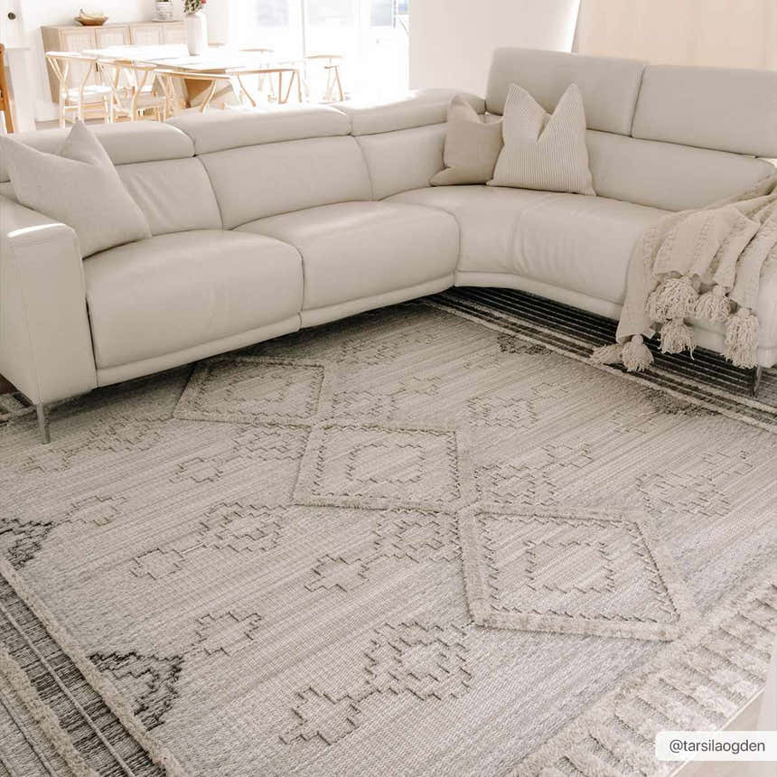 Living room with cream sectional sofa and light beige Amaga High-Low Rustic Rug with geometric pattern. Roomscene-Rectangle