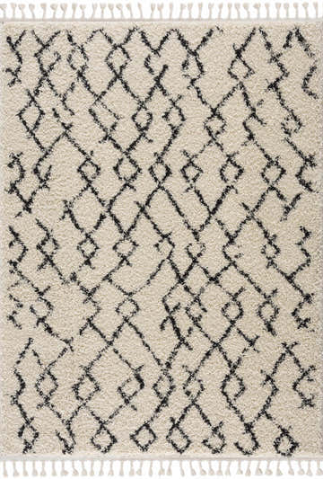 Close-up of Pahala Moroccan Shag Area Rug. Beige shag rug with charcoal geometric diamond pattern and tassels. Bohemian style. Design-Rectangle-5373