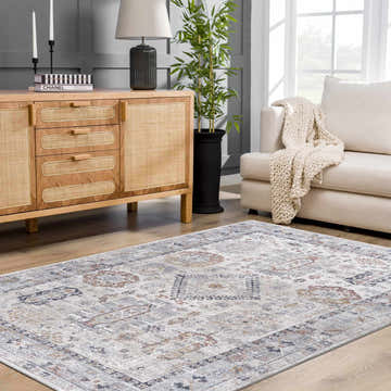Living room scene with a light gray Kamau Area Rug, wood cabinet, white sofa, and natural light. Roomscene-Rectangle