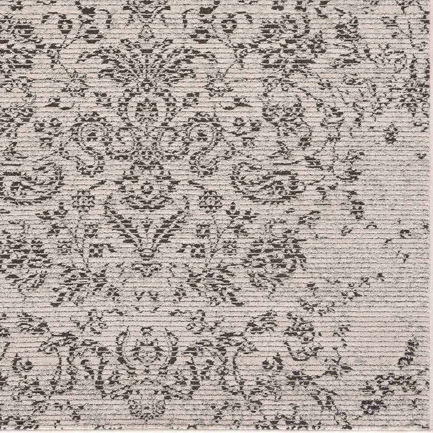 Close up of the Paicines Area Rug, a charcoal and light beige rug with a traditional, vintage pattern and subtle texture. Texture