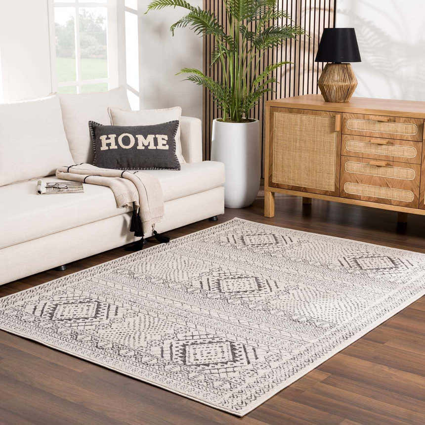 Living room scene with a beige sofa and the charcoal Merriott Area Rug on a dark wood floor. Roomscene-Rectangle