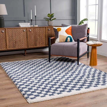 Living room scene with a Kieu Blue & White Checkered Area Rug, gray chair, wood cabinet, and natural light. Roomscene-Rectangle