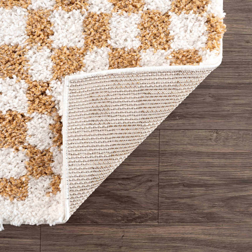 Close-up of the Kieu Mustard & Ivory Checkered Area Rug showing the shag texture, checker pattern, and rug backing. Fold