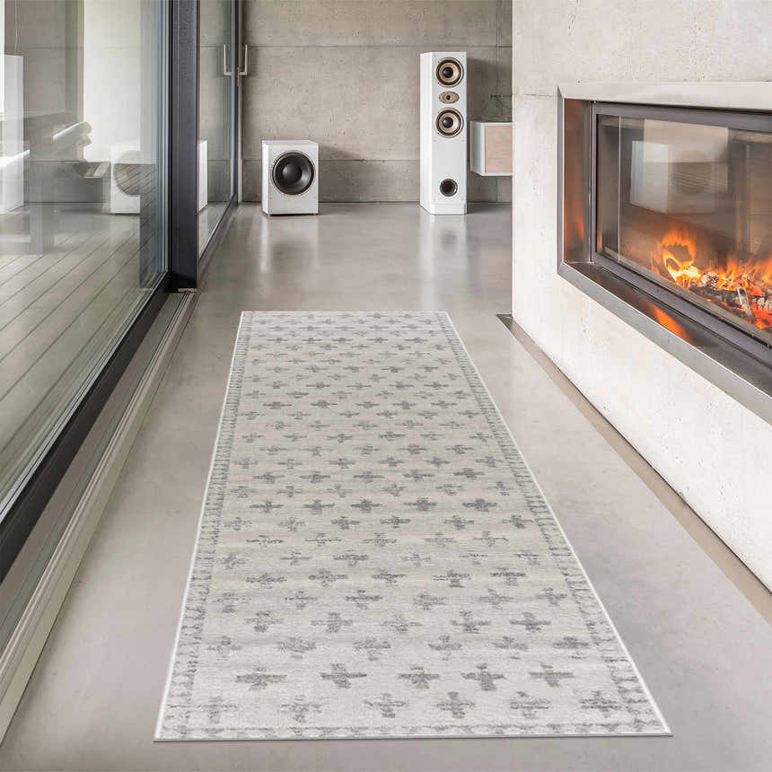 Modern living room with a Tigris Swiss Cross Ivory & Gray rug, fireplace, speakers, and concrete walls. Roomscene-Runner