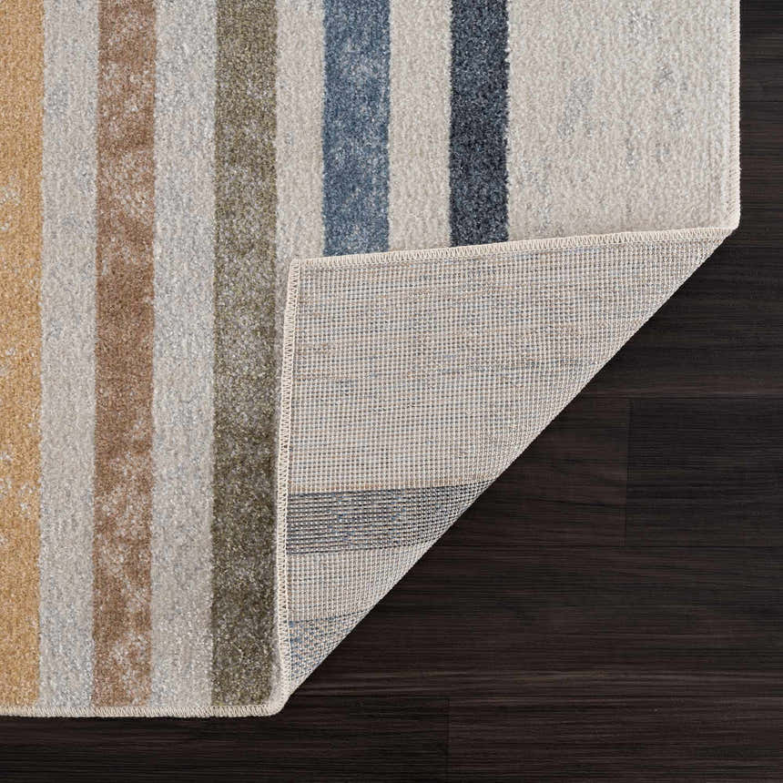 Close-up of Giza Washable Area Rug showing striped design in mustard, tan, blue, and off-white colors and rug backing. Fold