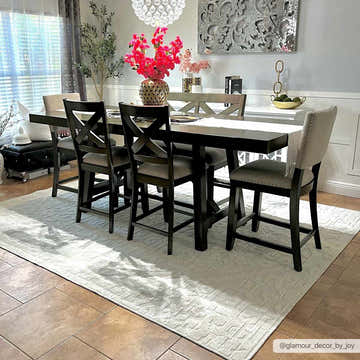 Dining room scene with a Beren Cream Washable Area Rug, dark wood table, upholstered chairs, and bright floral accents. Roomscene-Rectangle