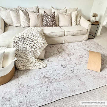 Living room scene with a beige sofa and the Bethany Vintage Flat Pile Washable Rug in beige and blush tones. Roomscene-Rectangle