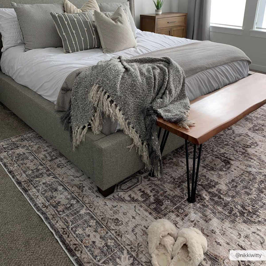 Bedroom scene with a gray upholstered bed and Bevin Washable Area Rug in dark brown and gray tones. Cozy, neutral palette. Roomscene-Rectangle
