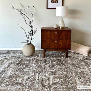 Bedroom scene with a brown wood nightstand on a Hera Flat Pile Washable Rug in brown, cream, and off-white. Roomscene-Rectangle