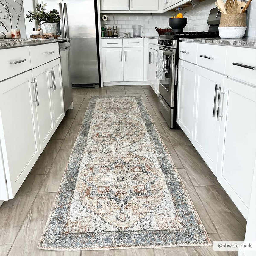 Bright kitchen scene with a Blue Orange Hera Washable rug runner between white cabinets and wood-look tile. Roomscene-Runner