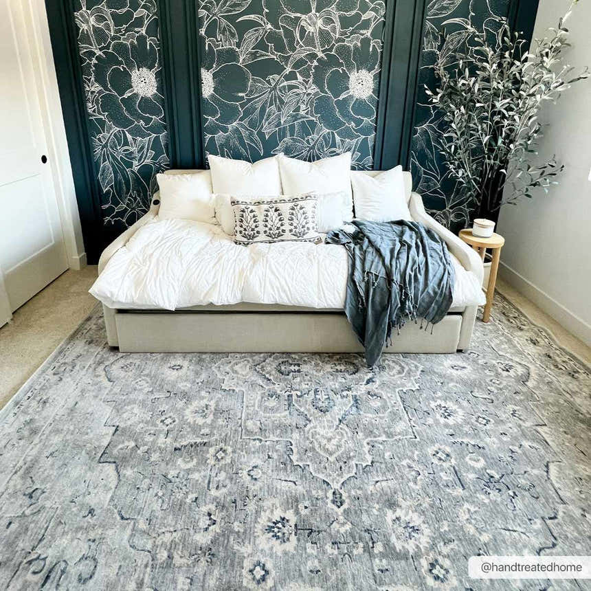 Bedroom scene with a Brodhead Luxe Area Rug in gray, styled under a daybed with floral wallpaper. Roomscene-Rectangle