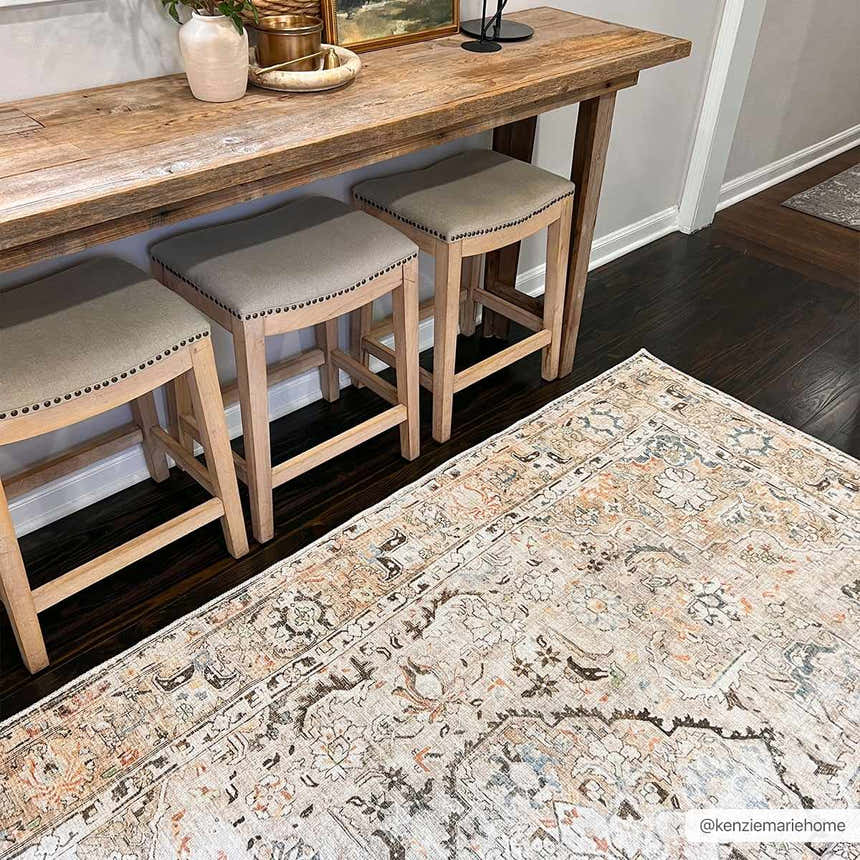 Entryway with Standon Vintage Flat Pile Washable Rug, wood console table, and stools on dark wood floors. Styleshot
