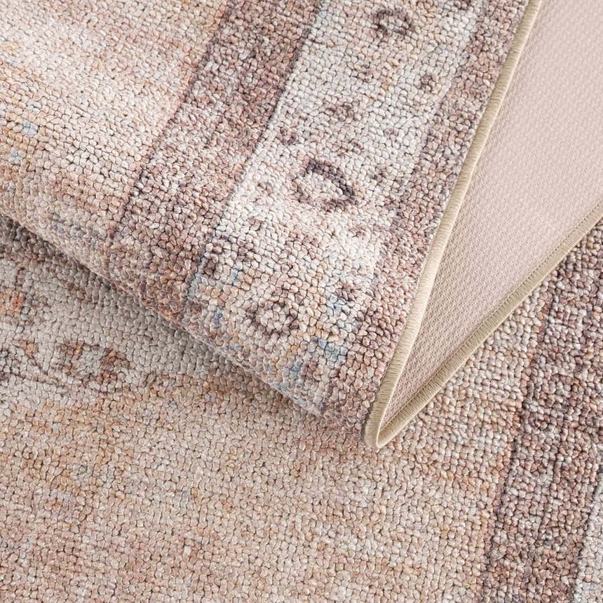 Close-up of the Analu Non-Slip Washable Rug, showing its tan, brown, and light blue rustic vintage pattern and non-slip backing. Fold