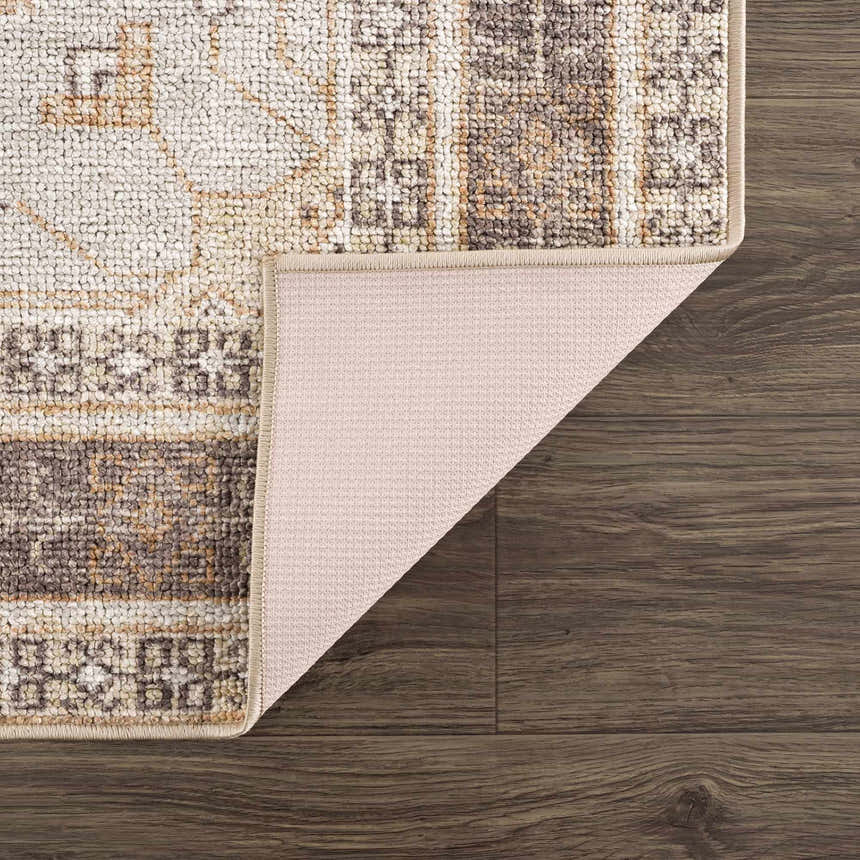 Close-up of the Albas Washable Area Rug showing its traditional vintage pattern, dark brown, light brown, and light blue colors. Fold