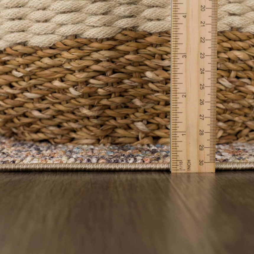 Close-up of the Beck Peach Washable Area Rug showing the rug's pile height and texture with beige, blue, and brown tones. Pile