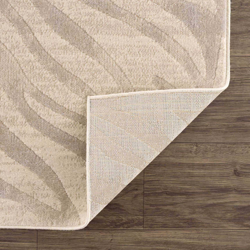 Close-up of Beige Manteca Zebra Print Area Rug showing the light beige and gray animal pattern and rug backing. Fold