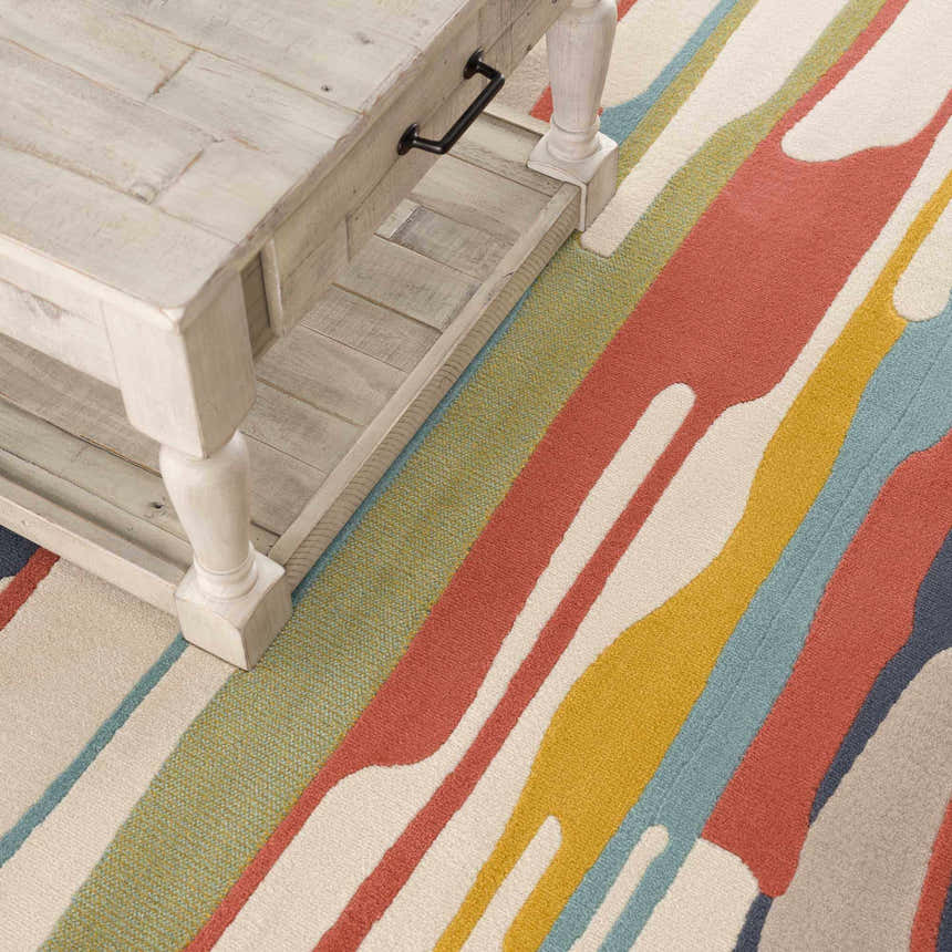 Close-up of Southfields Colorful Modern Area Carpet with aqua, mustard, and peach stripes under a light beige wooden coffee table. Styleshot