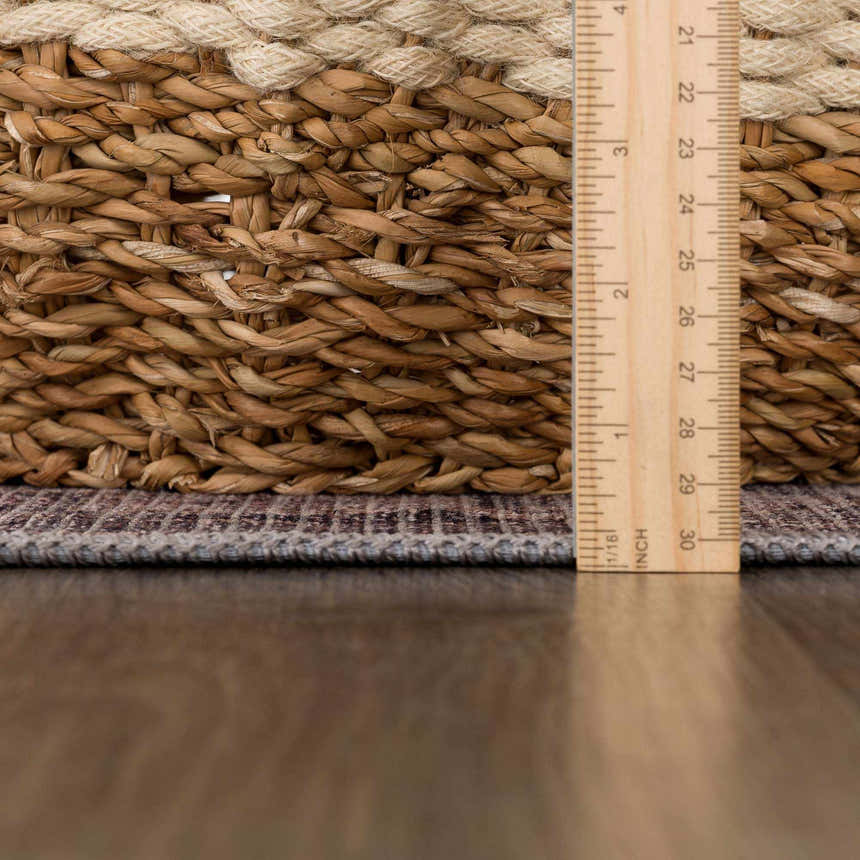 Close-up of the Greenpoint Dusty Blue Washable Rug showing texture and pile height next to a ruler and woven basket. Pile