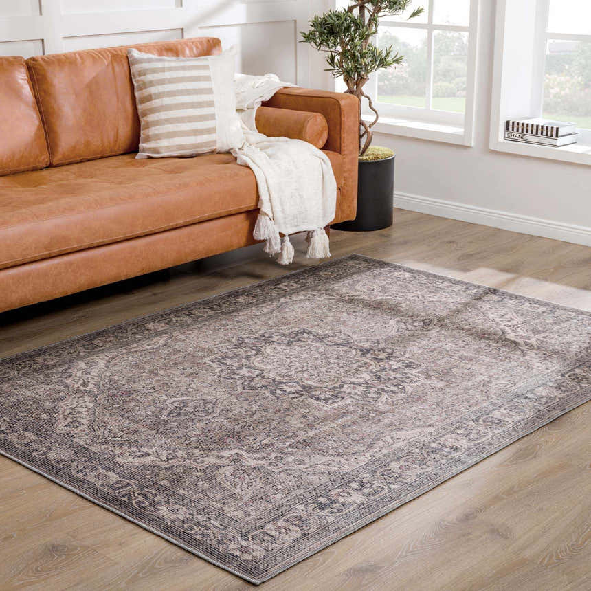 Living room scene with a Greenpoint Dusty Blue Washable Rug, tan leather sofa, and light wood floors. Neutral, cozy aesthetic. Roomscene-Rectangle