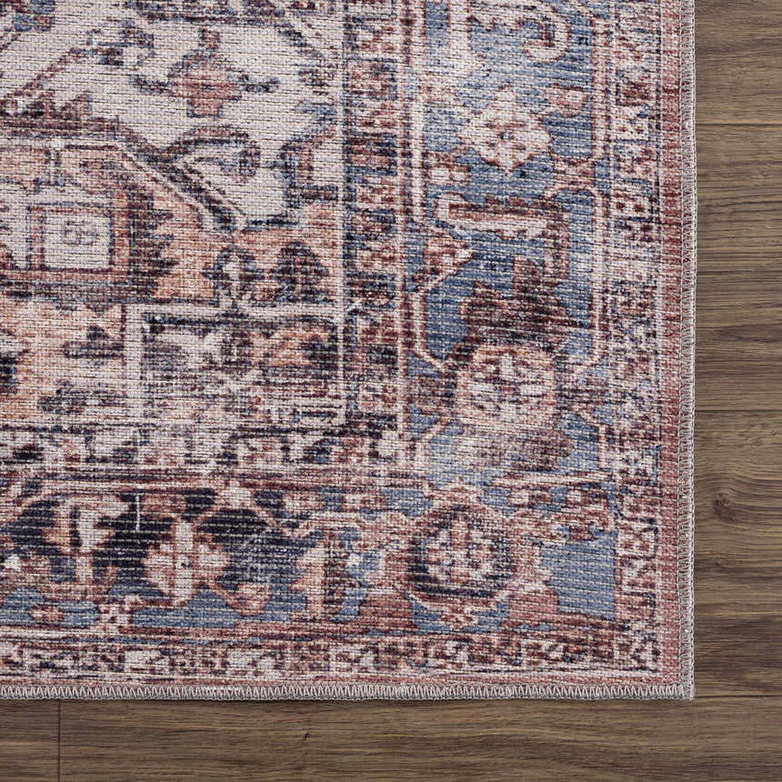 Close-up of Viho Vintage Flat Pile Washable Rug. Traditional design in brown, blue, peach, and white on wood floor. Swatch