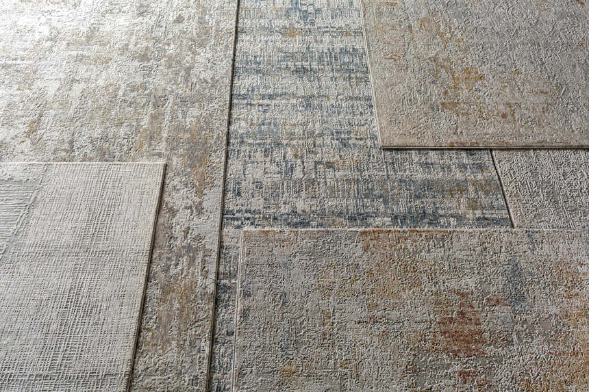 Close-up of the textured Dowell Luxe Area Rug showing its brown, gray, off-white, and dark blue color palette. Styleshot