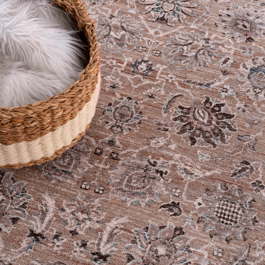 Close-up of the Civankan Area Rug, a clearance item, showcasing brick red, brown, and blue floral oriental pattern. Wicker basket detail. Styleshot