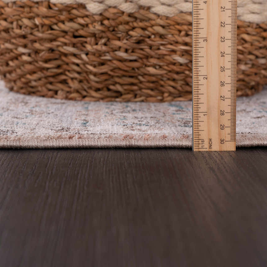Close-up of the Civankan Area Rug showing the pile height with a ruler and a basket, revealing its texture and construction. Pile