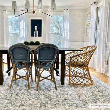 Dining room scene with a Carlton Area Rug in blush, brown, and cream under a dark wood table and blue woven chairs. Roomscene-Rectangle