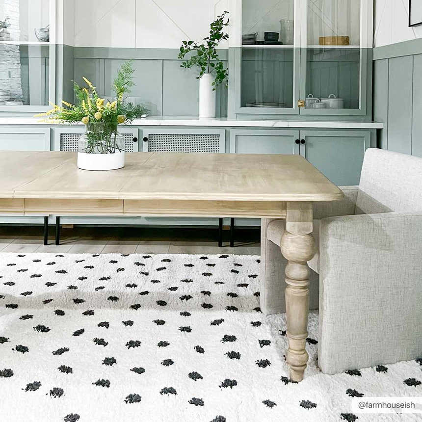 Dining room with light wood table and Chaia Dotted Black & White Plush Rug, creating a modern, cozy feel. Roomscene-Rectangle