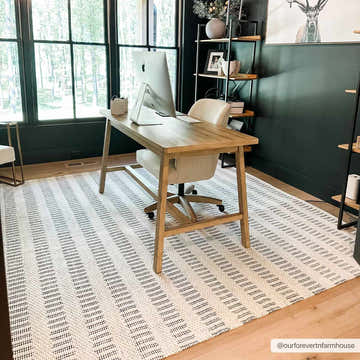 Home office with a light wood desk on a bone and gray Circe Wool Area Rug. Dark green walls and natural light. Roomscene-Rectangle