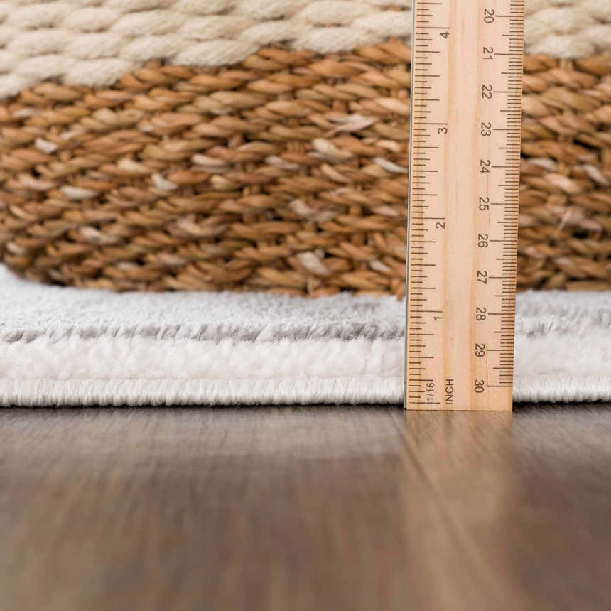 Close-up of the Azana Modern Gray Area Rug showing rug thickness with ruler and basket. Cream and gray rug texture. Pile