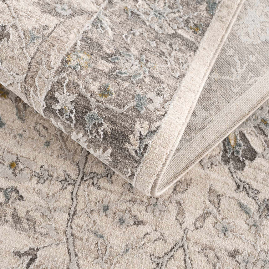 Close-up of the Gauge Cream & Gray Blue Rug, showcasing its traditional pattern, soft texture, and neutral color palette. Fold
