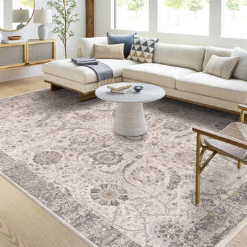 Living room with a Gauge Cream & Gray Blue Rug, white sofa, and round coffee table. Neutral tones create a calming space. Roomscene-Rectangle