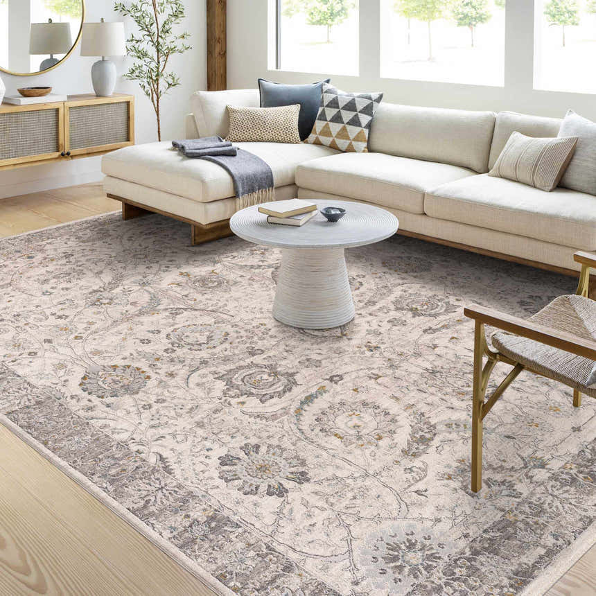 Living room with a Gauge Cream & Gray Blue Rug, white sofa, and round coffee table. Neutral tones create a calming space. Roomscene-Rectangle