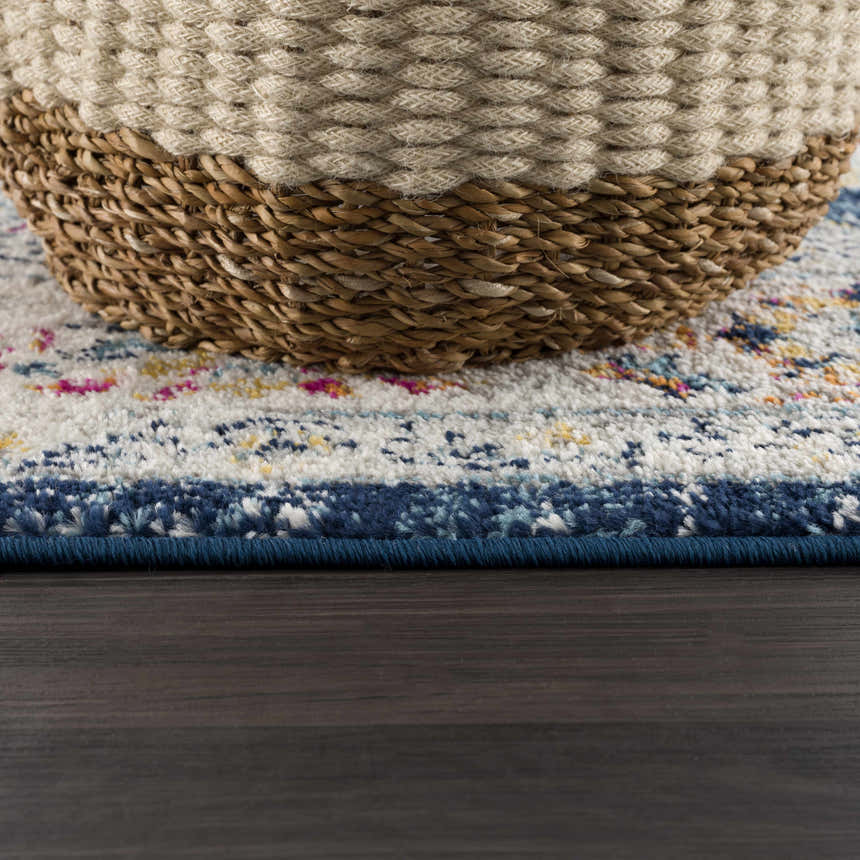 Close-up of the Marash KMRSH-4603 runner rug showing navy, orange, pink, and white details with a woven basket on top. Pile