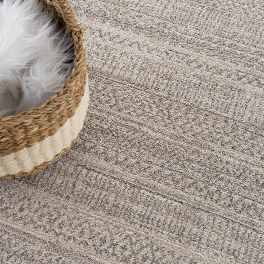 Close-up of the Nate Beige Tribal high pile carpet, showing texture and subtle tribal pattern. Basket with white fur accents. Styleshot