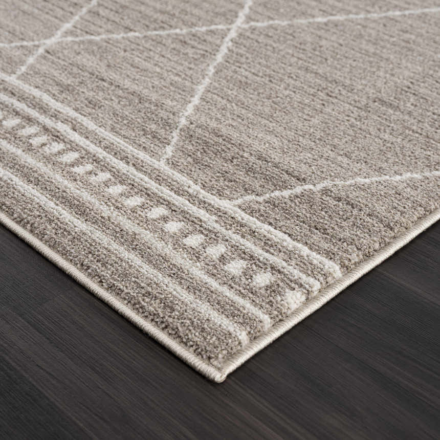 Close-up of the Kami Area Rug. Dark beige rug with ivory geometric Moroccan design and textured weave. Corner